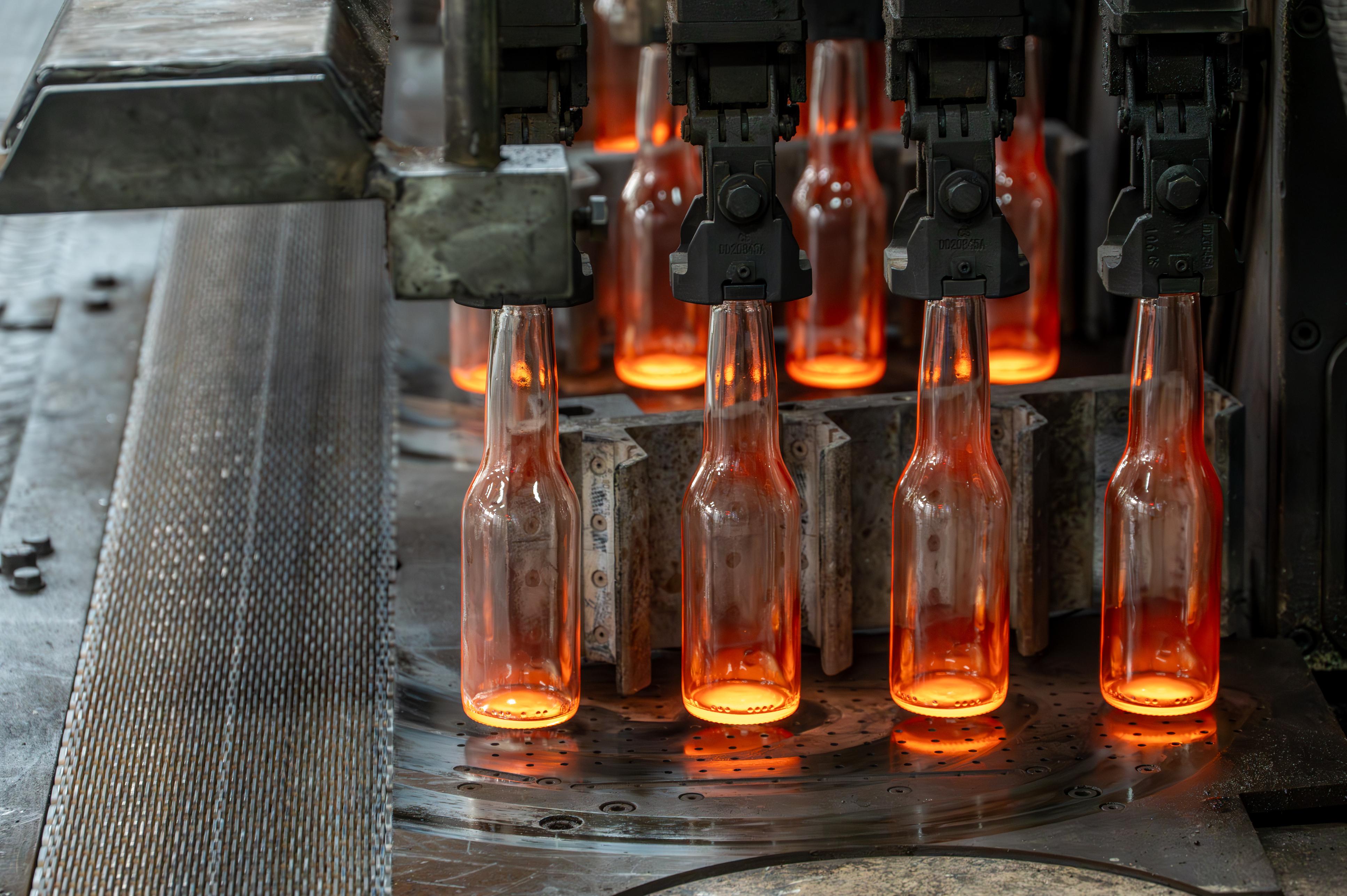 Glass forming machine shaping molten container glass